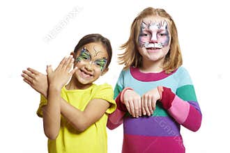 Young girls with face painting of cat and butterfly