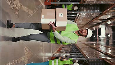 African American Male Worker in Uniform Dancing with Cardboxes and Having Fun at Warehouse. Joy in the Workplace
