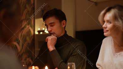 Tracking shot of happy Caucasian family gathering at home having dinner celebrating Christmas. Beautiful people gathered