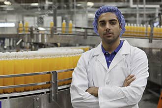 Portrait of confident factory worker standing with arms crossed