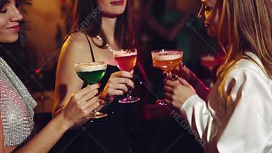 Happy, beautiful young girls, meeting in bar, drinking cocktails, dancing, celebrating birthday and holiday. Christmas