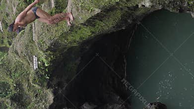 A Man dive from cliff and swim. Tourist jump to clear water of mountain river