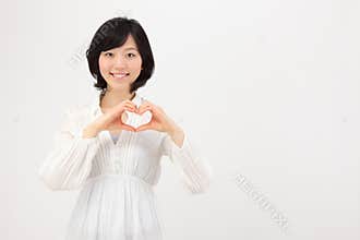 Young Asian woman making heart with hands
