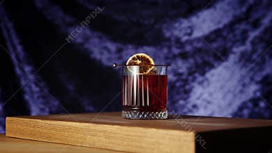 Bartender putting cherry into negroni cocktail. Dark background. Gin, sweet vermouth, red Campari bitter liqueur