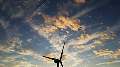 Drone shot wind turbine during colorful sunset at night. Beautiful colorful cloudy sky. Windmills producing clean green energy.