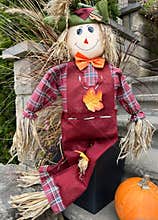 Autumn and Halloween decorative doll with pumpkin in front of the house