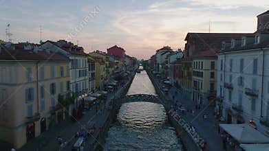 Forwards fly above historic water canal, people strolling on waterfronts with various stands. Tourist destination at
