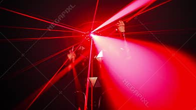 Red neon lights with man walking from black background performing contemporary dance. Front view portrait of confident