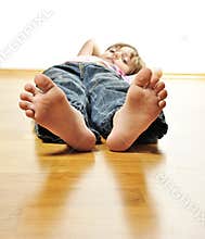 Little girl resting on a wooden floor