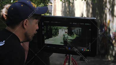 Cinematographer controls process of movie making on monitor
