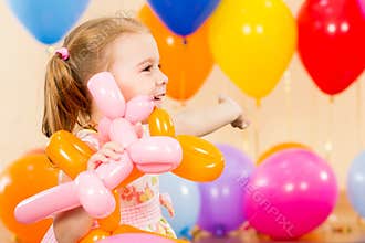Happy child girl with balloons on birthday party