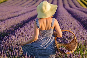 Young woman enjoys walking in lavender field on sunny day