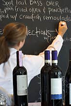 Waitress, menu board, and wine