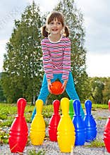 Happy little girl playing bowling