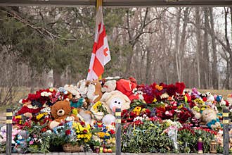 Toys and flowers lie at a trolleybus stop next to a house blown up by a Russian rocket on Pobeda in the city of Dnepr in Ukraine