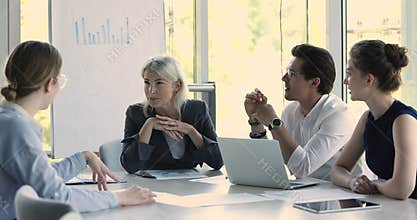 Group of friendly and successful businesspeople talking meet in boardroom