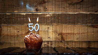 Background happy birthday pie or muffin with candles burning digit number 50. Festive card Happy Birthday on the background of
