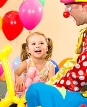 Happy kid and clown play on birthday party
