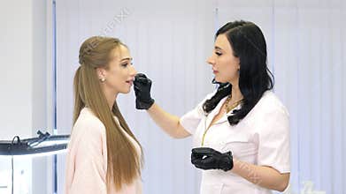 Beauty injections. Lip augmentation procedure. Beautician prepares lips for lip augmentation. The cosmetologist in