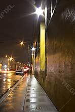 Bright Wet City Sidewalk and Street At Night