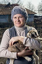 Woman embracing a goatling.