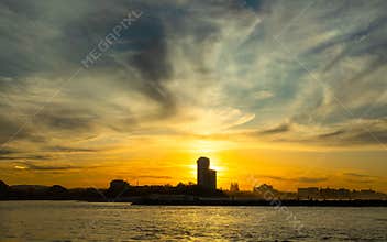 Sunset with silhouette skyline over water