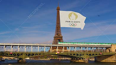 Aerial view of downtown Paris. A drone flies over the Seine River towards the Eiffel Tower. Green trees adorn the