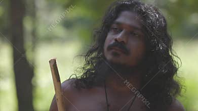 Portrait of Vedda tribesman of Sri Lanka stands in natural surroundings, representing indigenous culture. Tribal