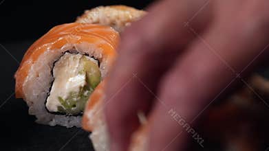 Placing sushi rolls on a plate.