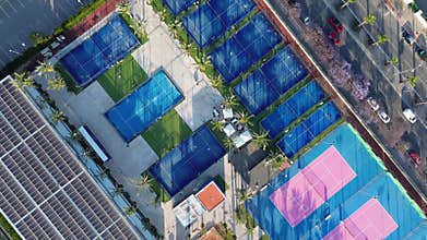 Aerial footage of a vibrant sports complex with tennis courts and a pool