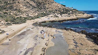 This video features a coastal scene with individuals walking along a cliffside