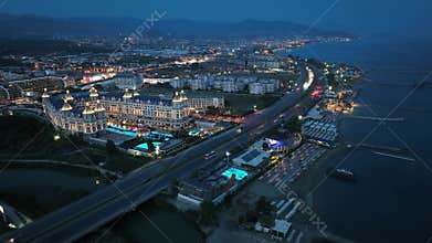 Stunning aerial sunset to night transition over Turkler in Alanya, Turkey. Alanya coastline,resorts,marina,hotels and city lights