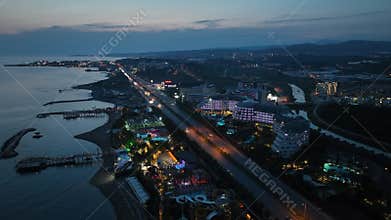 Stunning aerial sunset to night transition over Turkler in Alanya, Turkey. Alanya coastline,resorts,marina,hotels and city lights