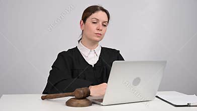 Female judge delivers verdict and bangs on gavel. Online court.