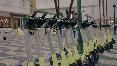 Row of Electric Scooters Lined Up on Pedestrian Street in Portugal