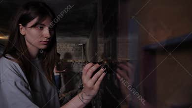 A woman driving a magnet along a glass wall with a maze in a quest room.
