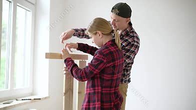 Dad teaching daughter to assemble furniture