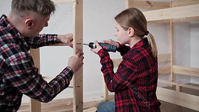 Dad teaching daughter to assemble furniture