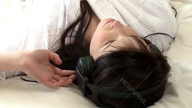 Charming woman listening music lying on bed