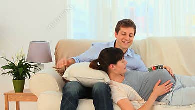 Couple playing on the belly of the pregnant woman