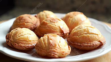 Delightful Golden Brown Bu?uelos Displayed on White Plate on Wooden Table Showcasing Intricate Patterns and Textures Perfect for
