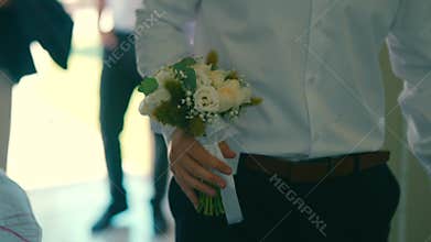Man walking with wedding bouquet.