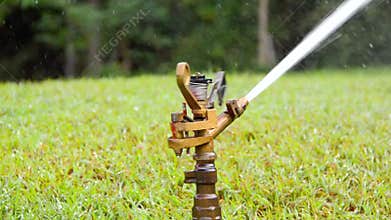 Automatic-sprinkler shooting water on the field