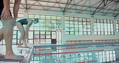 Female swimmer stepping onto block 4 and adjusting goggles, male swimmer crouching for start