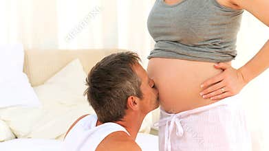Male kissing the belly of his pregnant wife