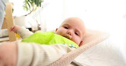 Adorable baby enjoying mealtime in bouncer