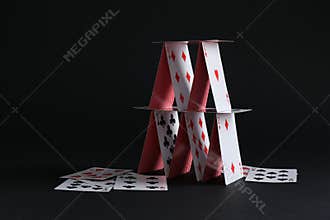 House of playing cards on black background. Space for text