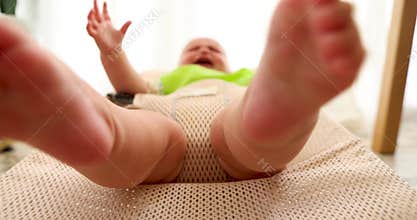 Baby kicking and moving legs on bouncer