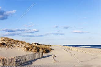 Beach Fence, Sand, Houses and the Ocean.