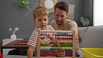 Father and young son playing together at home using a colorful abacus on the sofa in a modern living room
